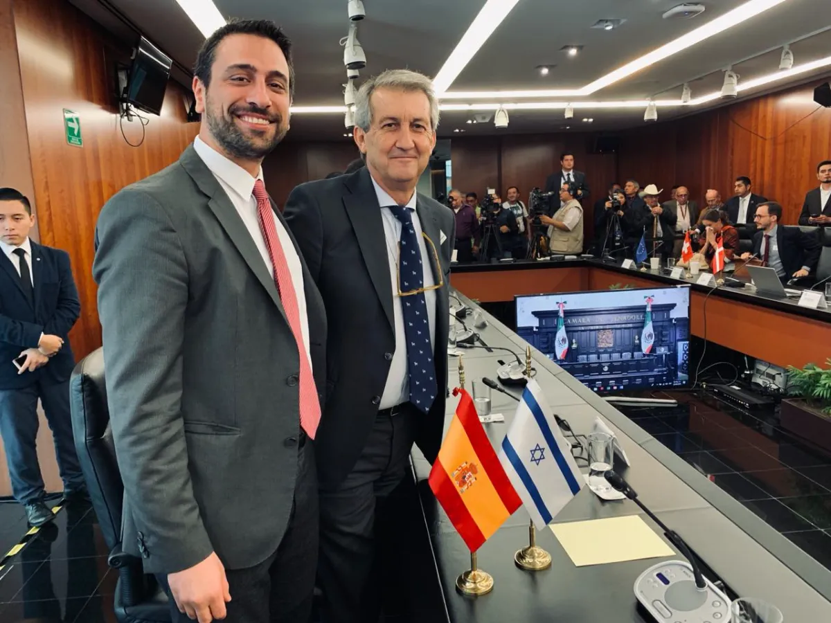 Uriel Raviv at a multilateral session in the Mexican Senate, with the Israeli and Spanish delegation flags on the table.